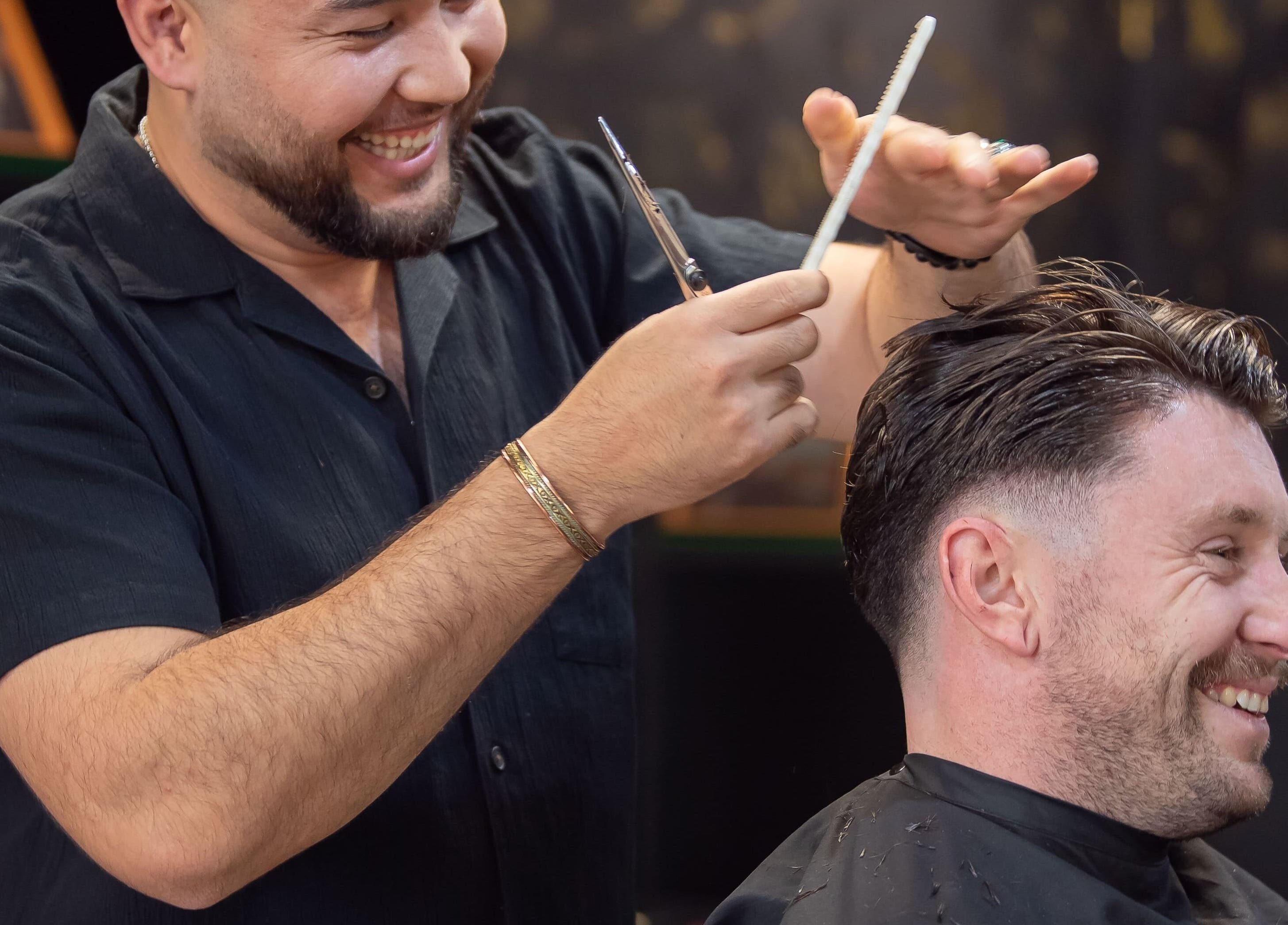 A barber joyfully cutting a customer's hair at The Rare Barber Shop in Auckland, Auckland, NZ.