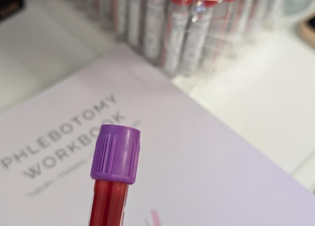 Phlebotomy workspace detail at MyRevibe, Douglas, IM showcasing medical tools and workbook.