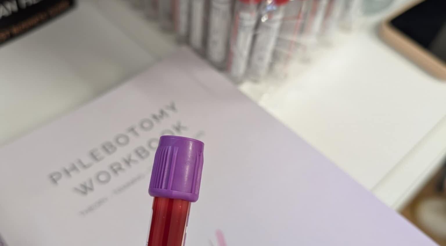 Phlebotomy workspace detail at MyRevibe, Douglas, IM showcasing medical tools and workbook.