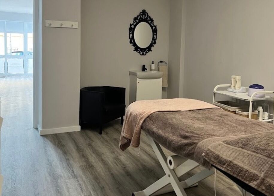 Sala de massagem tranquila no LOTUS STUDIO by Elsa, Lisboa, PT, com mesa e espelho decorativo.