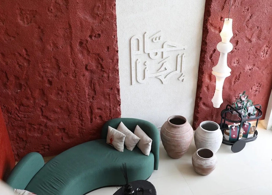 ركن داخلي في حمام الهنا بالرياض يشمل مقاعد وفخاريات لمسة فنية.