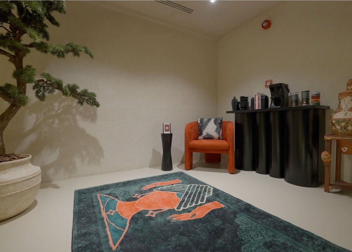 زاوية هادئة في حمام الهنا بالرياض، تتضمن كرسياً برتقاليًا وزخارف شرقية.