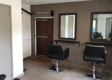 Stijlvolle salonstoelen bij Your HairStory, Winssen, Gelderland, NL met strakke wandontwerpen.