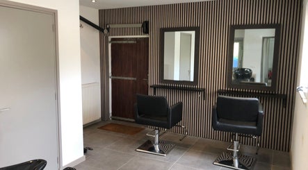 Stijlvolle salonstoelen bij Your HairStory, Winssen, Gelderland, NL met strakke wandontwerpen.