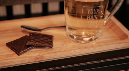 Glas thee met chocolade op een houten dienblad bij Your HairStory in Winssen, Gelderland, NL.
