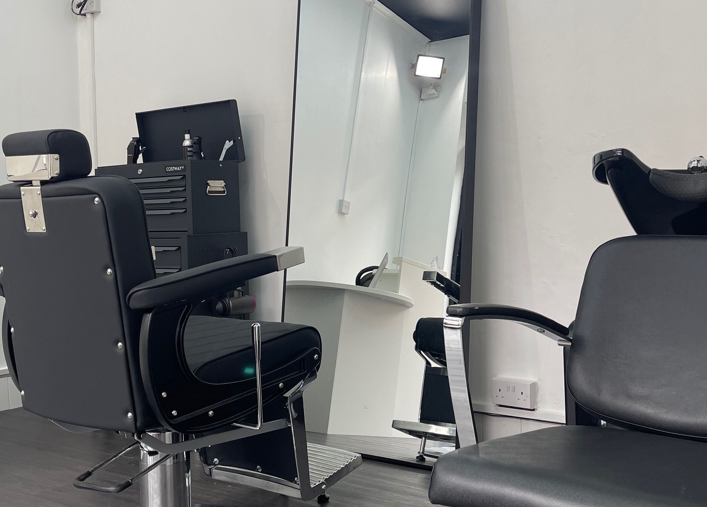 Stylish barber chair and station at Alexandre Cuts, London, England, GB, showcasing sleek interior design.