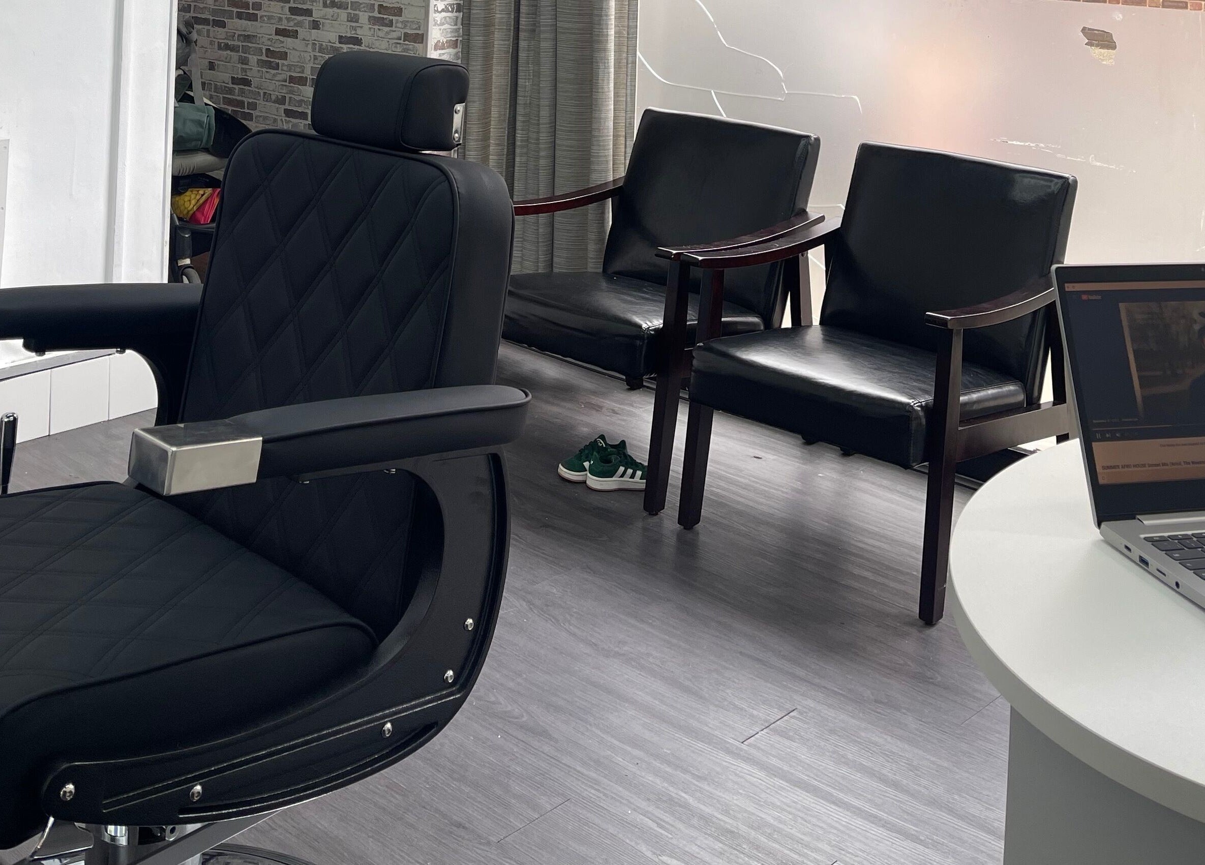 Interior of Alexandre Cuts in London, England, GB, showing stylish barber chair and sleek waiting area design.