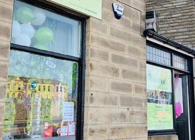 Exterior of Shriji Beauty touch, Huddersfield, England, showcasing welcoming windows and signage.