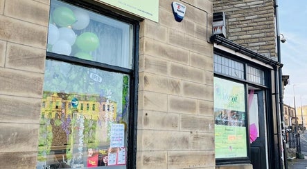 Exterior of Shriji Beauty touch, Huddersfield, England, showcasing welcoming windows and signage.