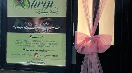 Entrance of Shriji Beauty Touch in Huddersfield, England, GB adorned with sign and pink decor.