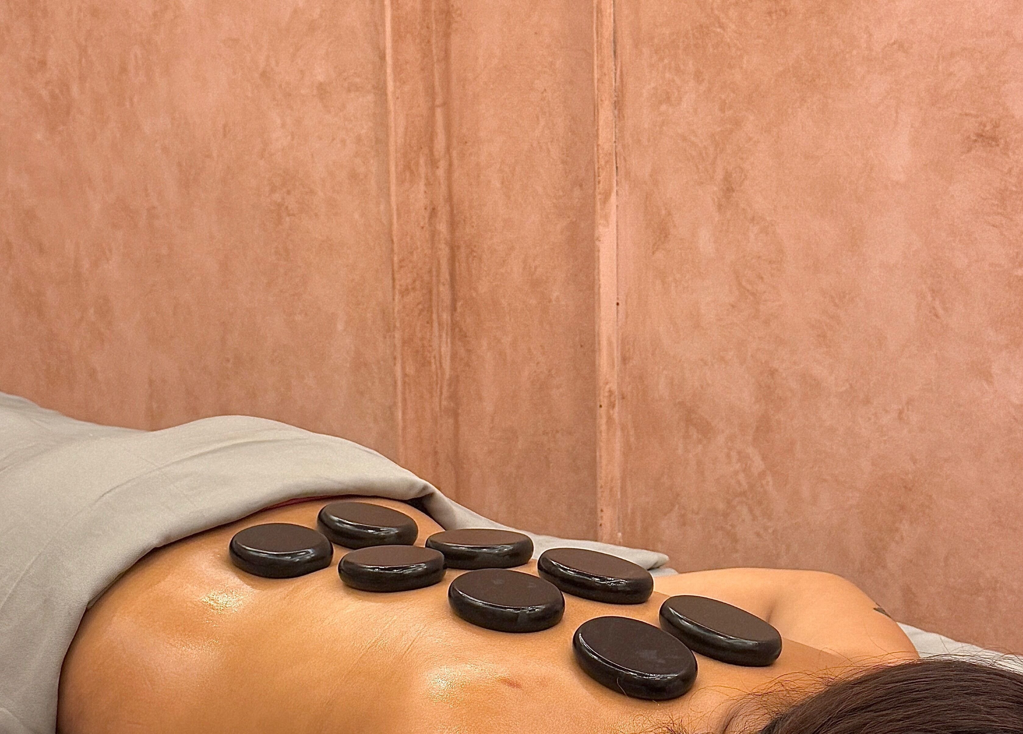 Hot stone massage at The Rustic Sun Spa - Berawa, Bali, Bali, ID, promoting relaxation and wellness.