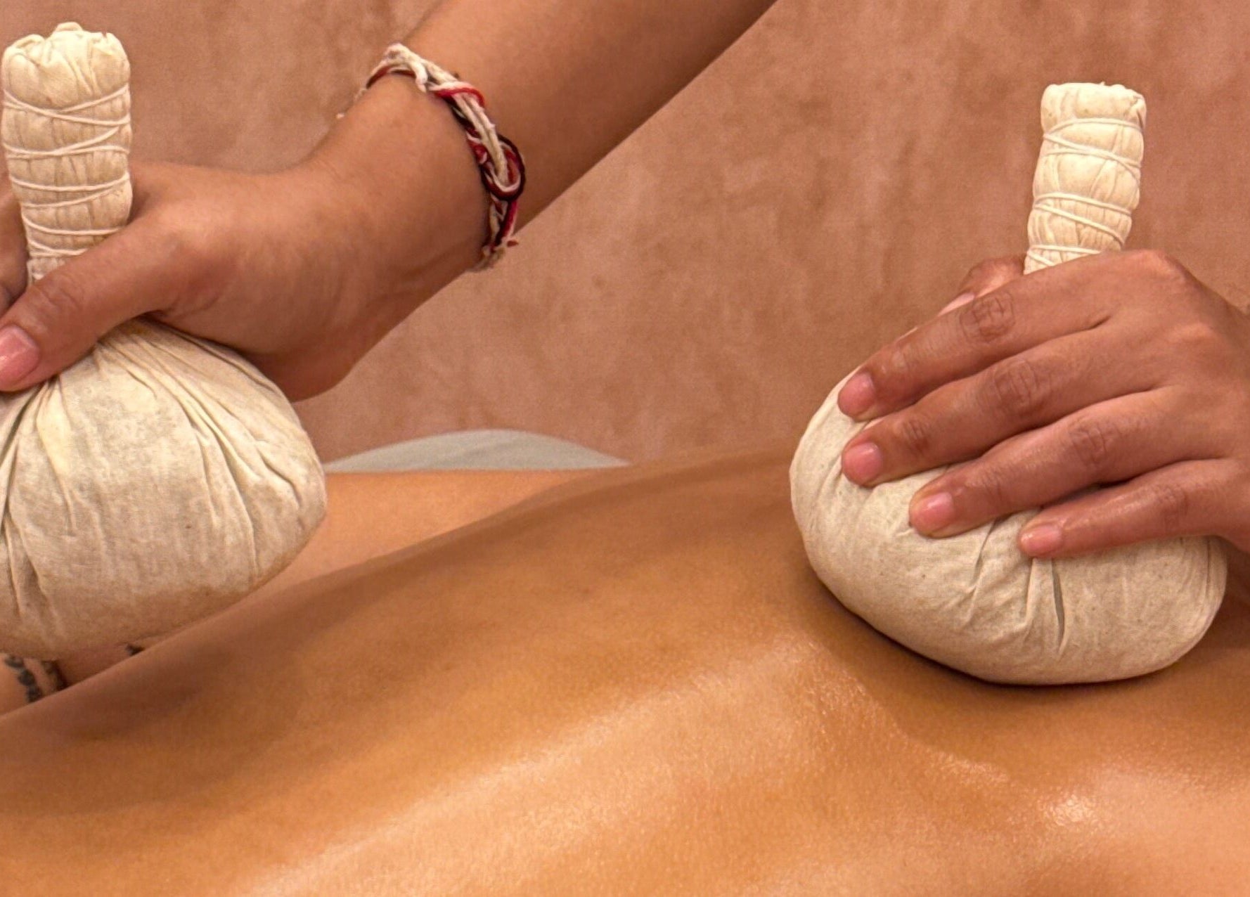 Therapist performs herbal massage at The Rustic Sun Spa - Berawa in Bali, Bali, ID.