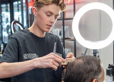Kapster bij Barbershop Best Barbers (Best) in Best, Noord-brabant, NL knipt zorgvuldig een klant.