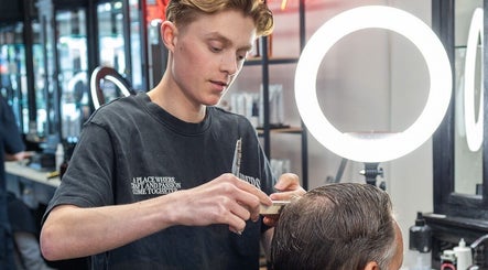Kapster bij Barbershop Best Barbers (Best) in Best, Noord-brabant, NL knipt zorgvuldig een klant.
