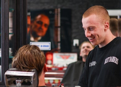 Kapper in Barbershop Best Barbers in gesprek met klant in Best, Noord-brabant, NL.