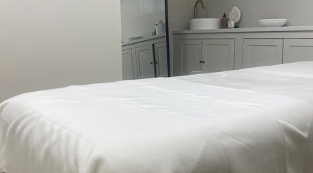 Elegant treatment room at Beauty by Ella in Derby, England, GB, featuring a plush white massage table.