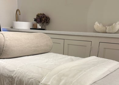 Relaxing treatment room at Beauty by Ella, Derby, England, GB with plush towel and soft lighting.