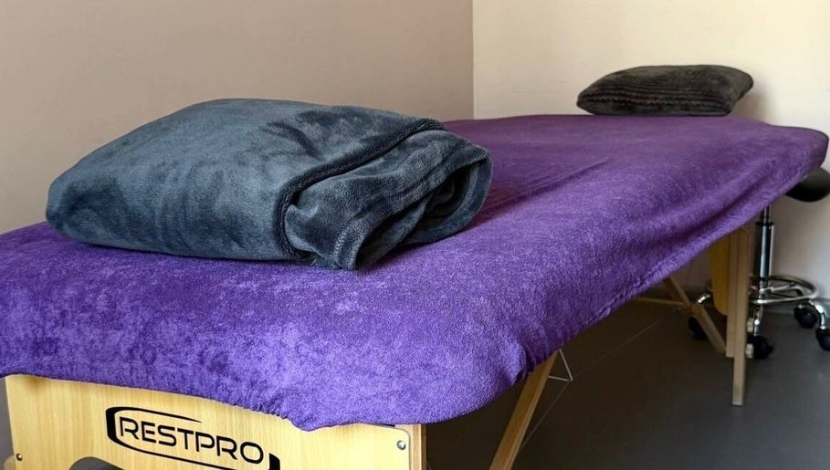 Massage table with purple cover at Energoterapija, Rīga, LV offering relaxation and wellness.