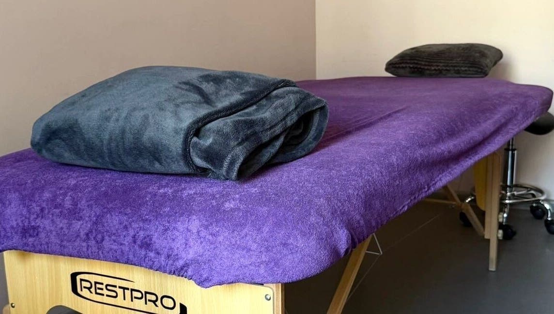 Massage table with purple cover at Energoterapija, Rīga, LV, offering relaxation and wellness.