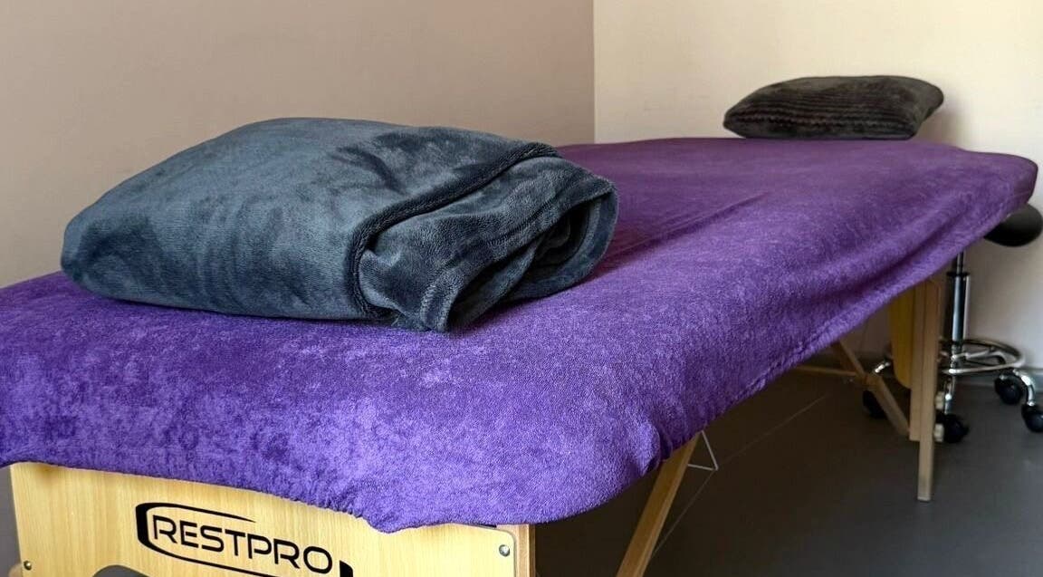 Massage table with purple cover at Energoterapija, Rīga, LV, offering relaxation and wellness.