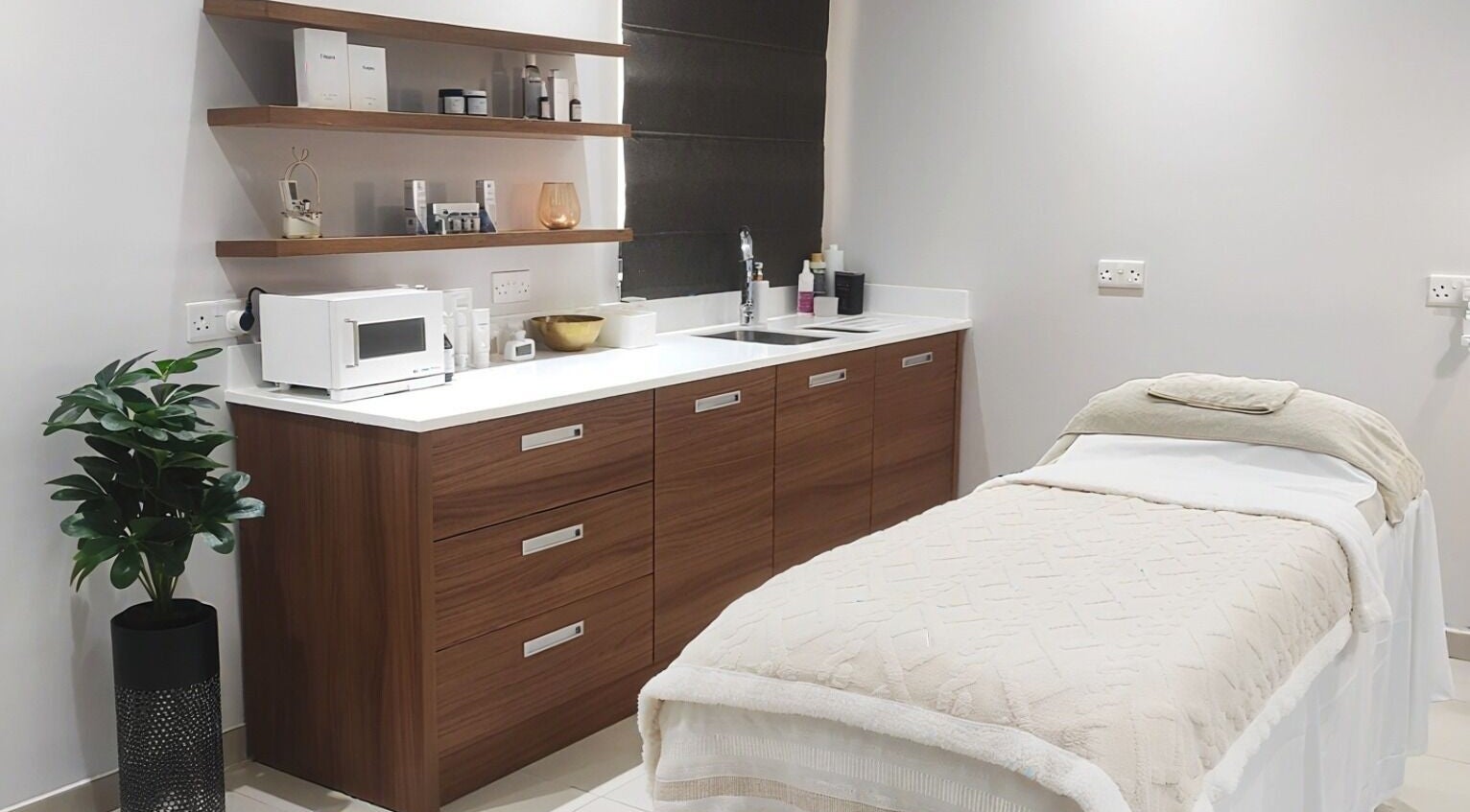 Relaxing treatment room at Aesthetics by Lourdes Zammit Calleja in Is-siġġiewi, MT with plush bed and products.