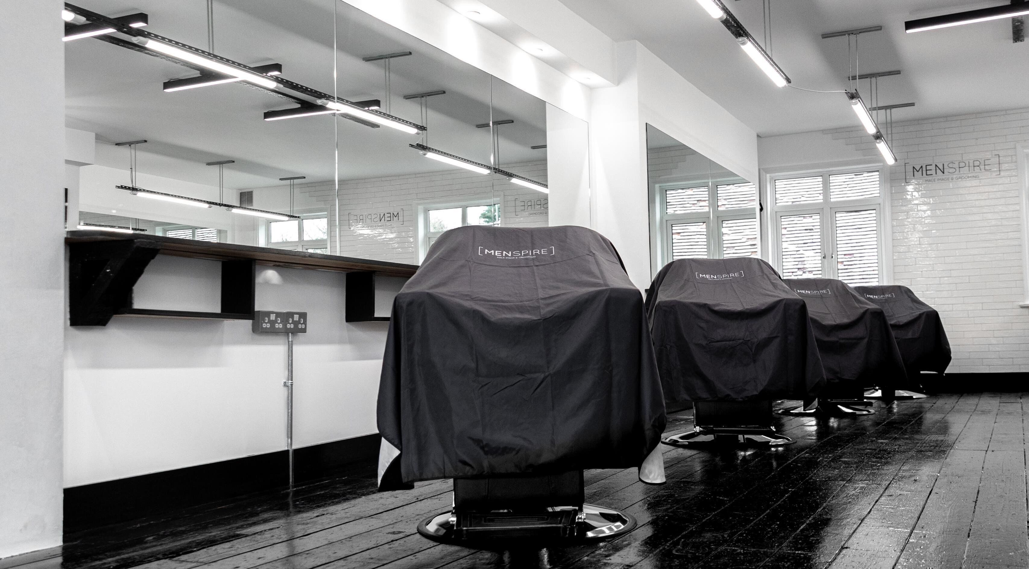 Interior of Menspire Radlett, a modern barbershop in Radlett, England, GB with chairs and mirrors.