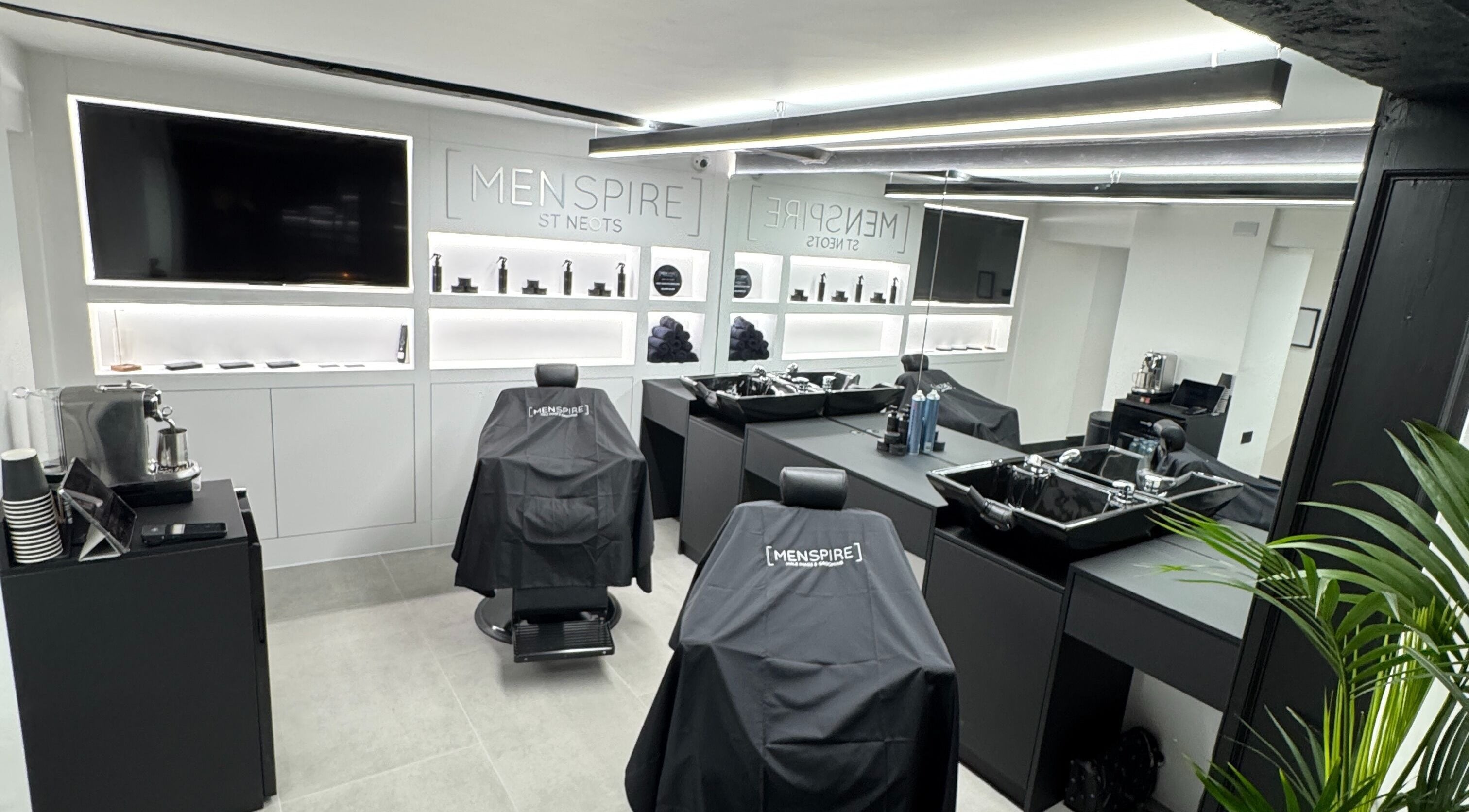 Sleek interior of Menspire St. Neots, Market Square, England, GB, showcasing modern barber chairs and equipment.