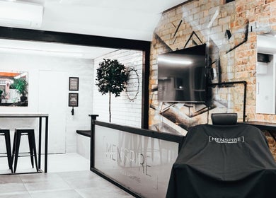 Modern interior of Menspire St Albans salon in St Albans, England with stylish decor and grooming chair.