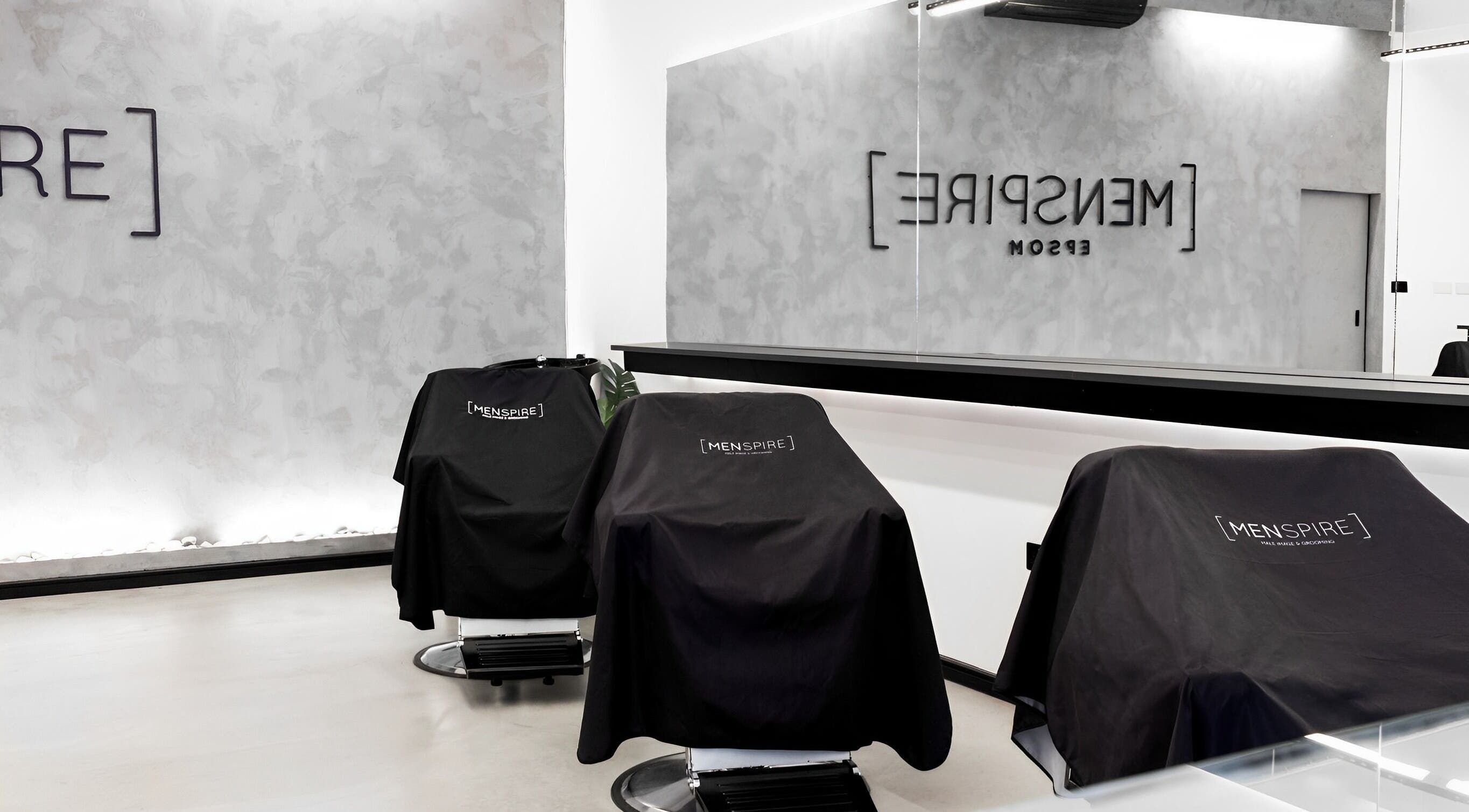 Sleek barber chairs in Menspire Epsom salon, Epsom, England, GB, featuring modern minimalist design.