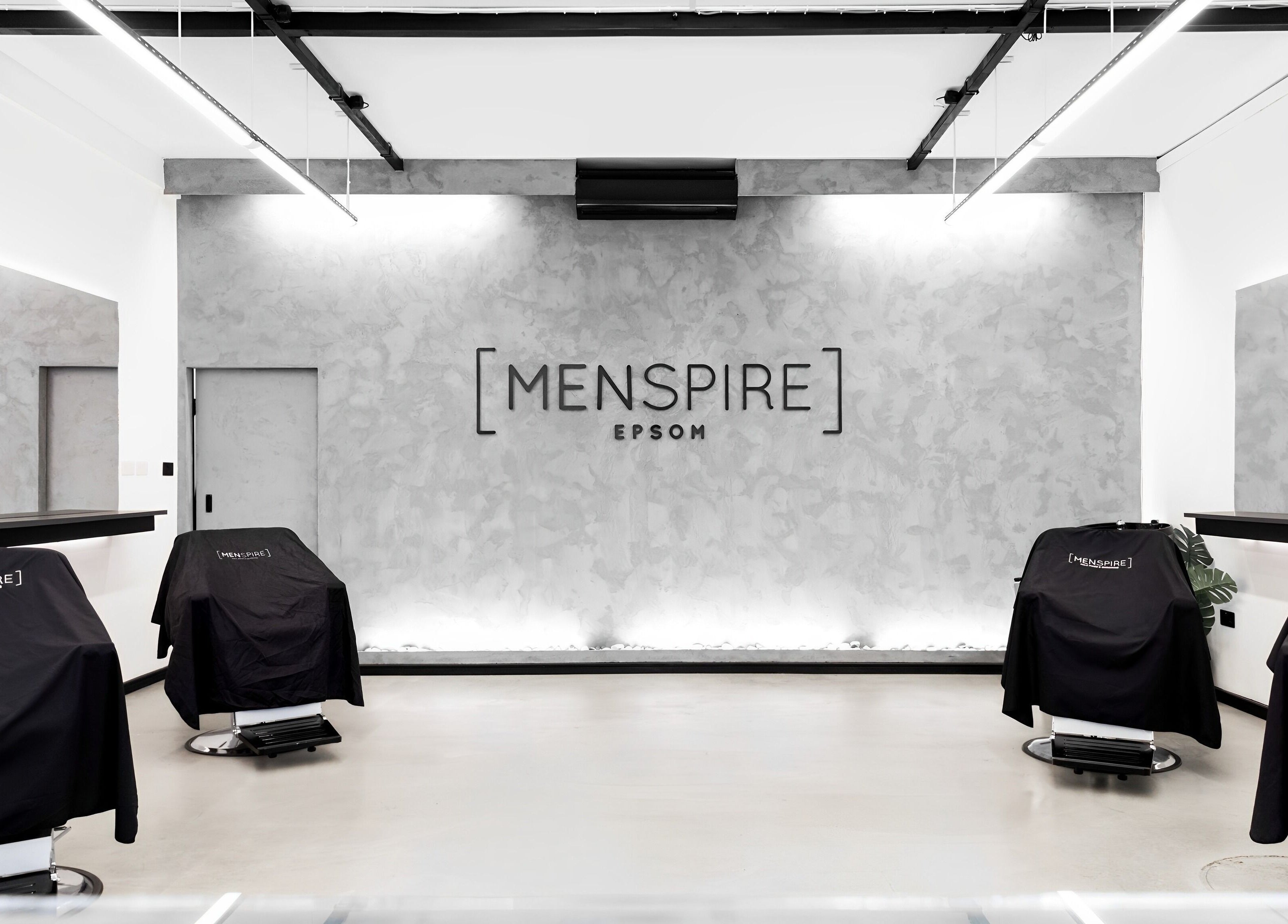 Modern interior of Menspire Epsom, Epsom, England, GB, showcasing sleek barber chairs and stylish decor.
