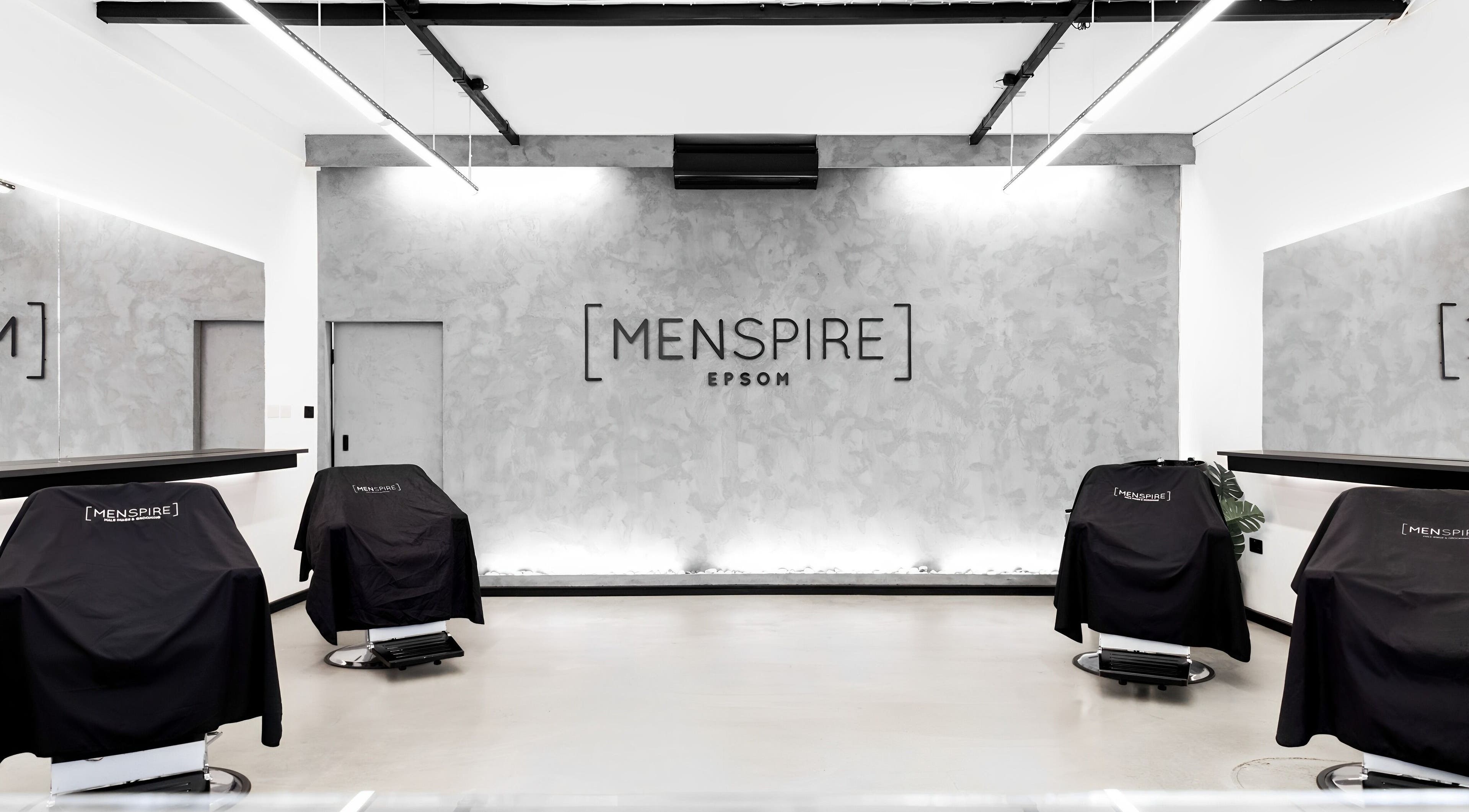 Modern interior of Menspire Epsom, Epsom, England, GB, showcasing sleek barber chairs and stylish decor.