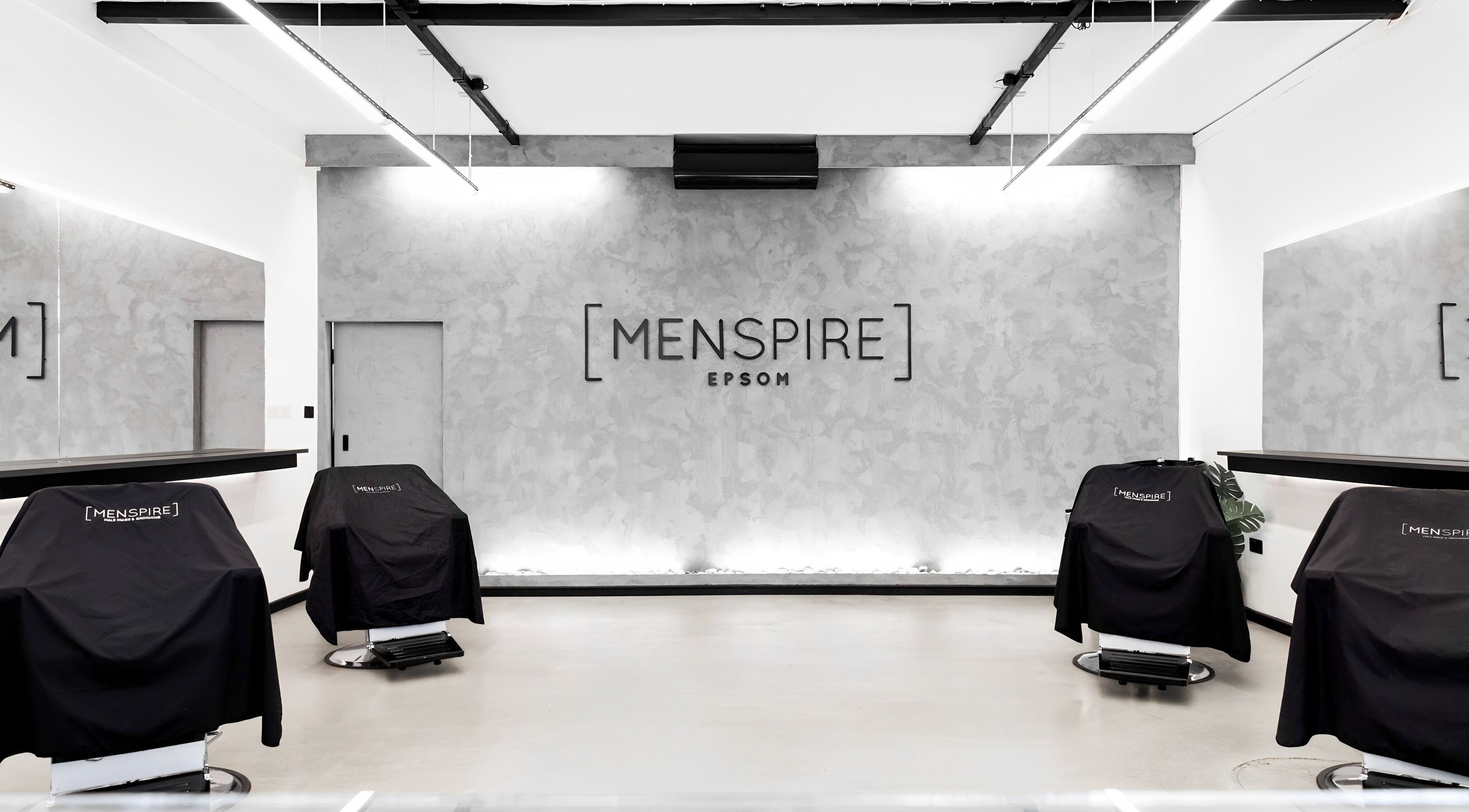 Modern interior of Menspire Epsom, Epsom, England, GB, showcasing sleek barber chairs and stylish decor.