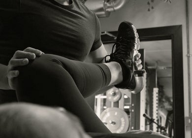 Personal trainer assists client with leg stretch at A Fitness - Health and Wellness Clinic, London, England, GB.