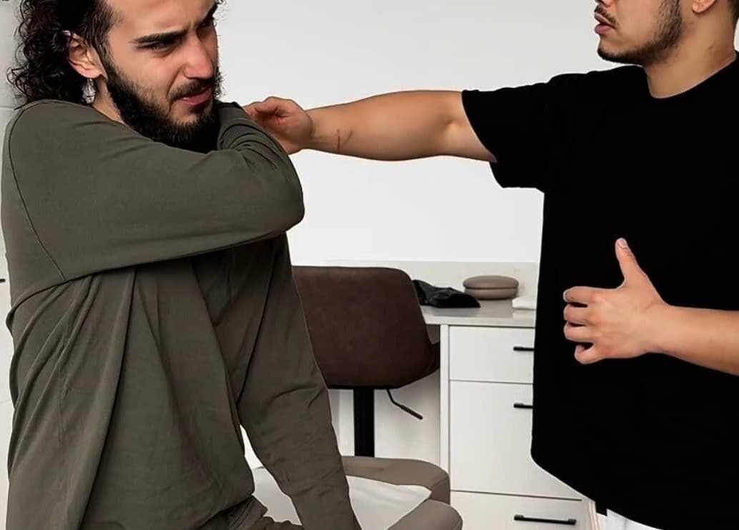 A therapist assists a client with shoulder exercises at A Fitness - Physical Therapy Clinic, London, England, GB.