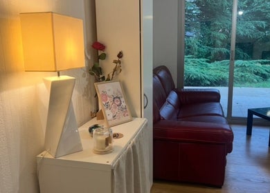 Intérieur chaleureux de Chez Léone à Naintré, Nouvelle-Aquitaine, FR avec canapé rouge et lampadaire.