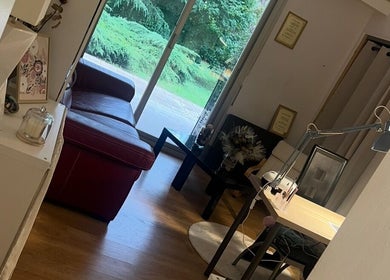 Salon chic à Chez Léone, Naintré, Nouvelle-Aquitaine, FR avec canapé rouge et vue sur le jardin.