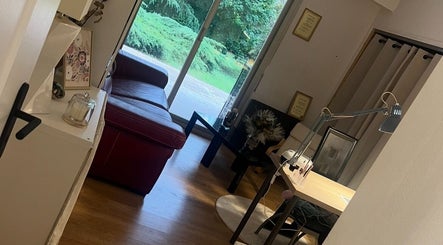 Salon chic à Chez Léone, Naintré, Nouvelle-Aquitaine, FR avec canapé rouge et vue sur le jardin.