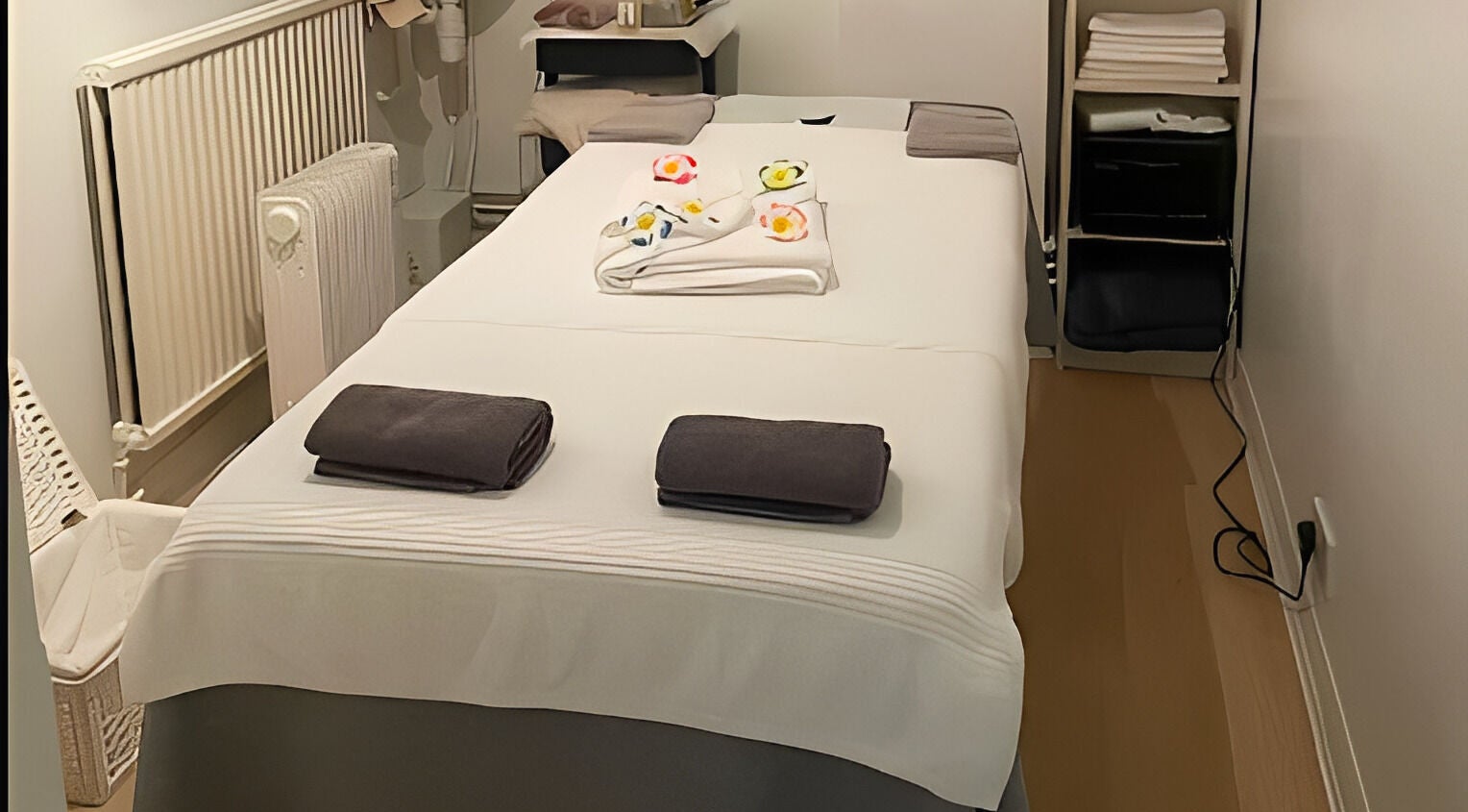 Massage room at Plumjai Thai Massage And Wellness in Saffron Walden, England, GB with neatly arranged towels.