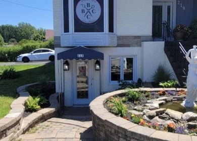 Entrée paisible de Mégan Ouellet à Rimouski, Québec, CA avec statue et jardin fleuri.