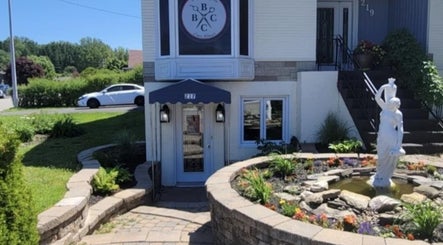 Entrée paisible de Mégan Ouellet à Rimouski, Québec, CA avec statue et jardin fleuri.