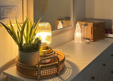 Warmly lit vanity at Radiance by Rylie, Boiling Springs, South Carolina, US, featuring plants and decorative lamp.