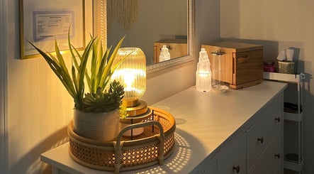 Warmly lit vanity at Radiance by Rylie, Boiling Springs, South Carolina, US, featuring plants and decorative lamp.
