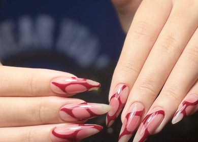 Stylish nail art with red patterns at Woo Salon Studio. Arcadia, California, US.