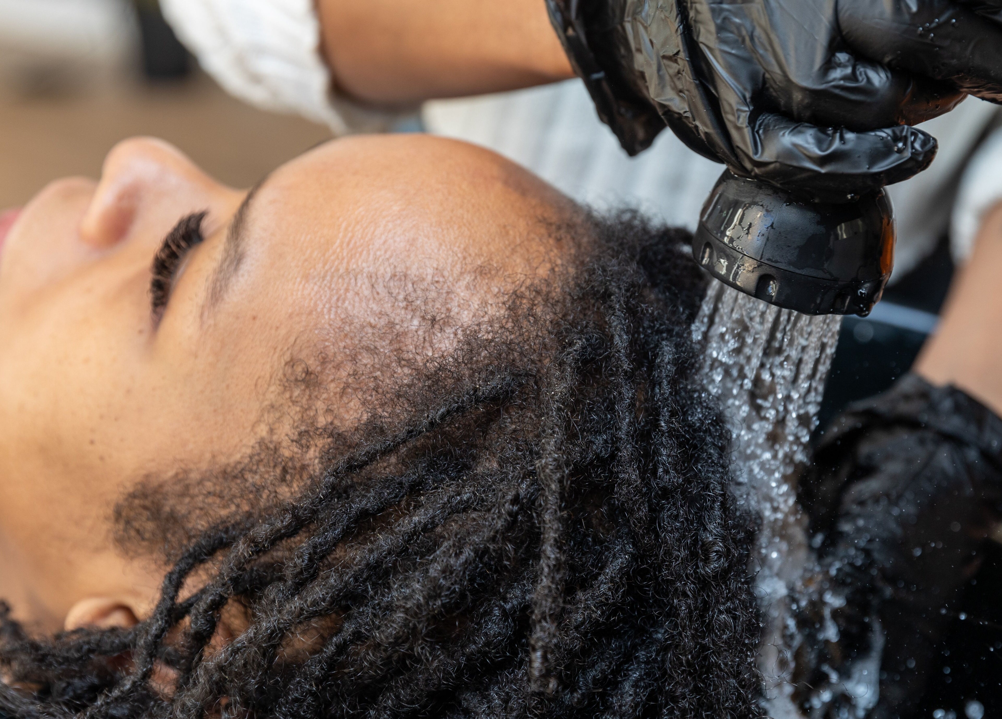 Client détendu lors d'un rinçage de cheveux à Xten'Cils - XC Masters, Salon et Academy, à Montréal, Québec, CA.