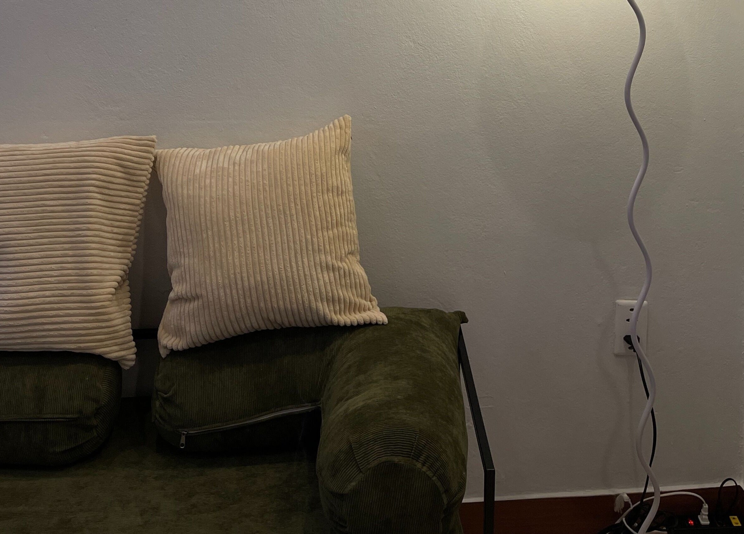 Comfortable seating area at BrowGal in Hà Nội, Hà Nội, VN, featuring a cozy green sofa with pillows and soft lighting.