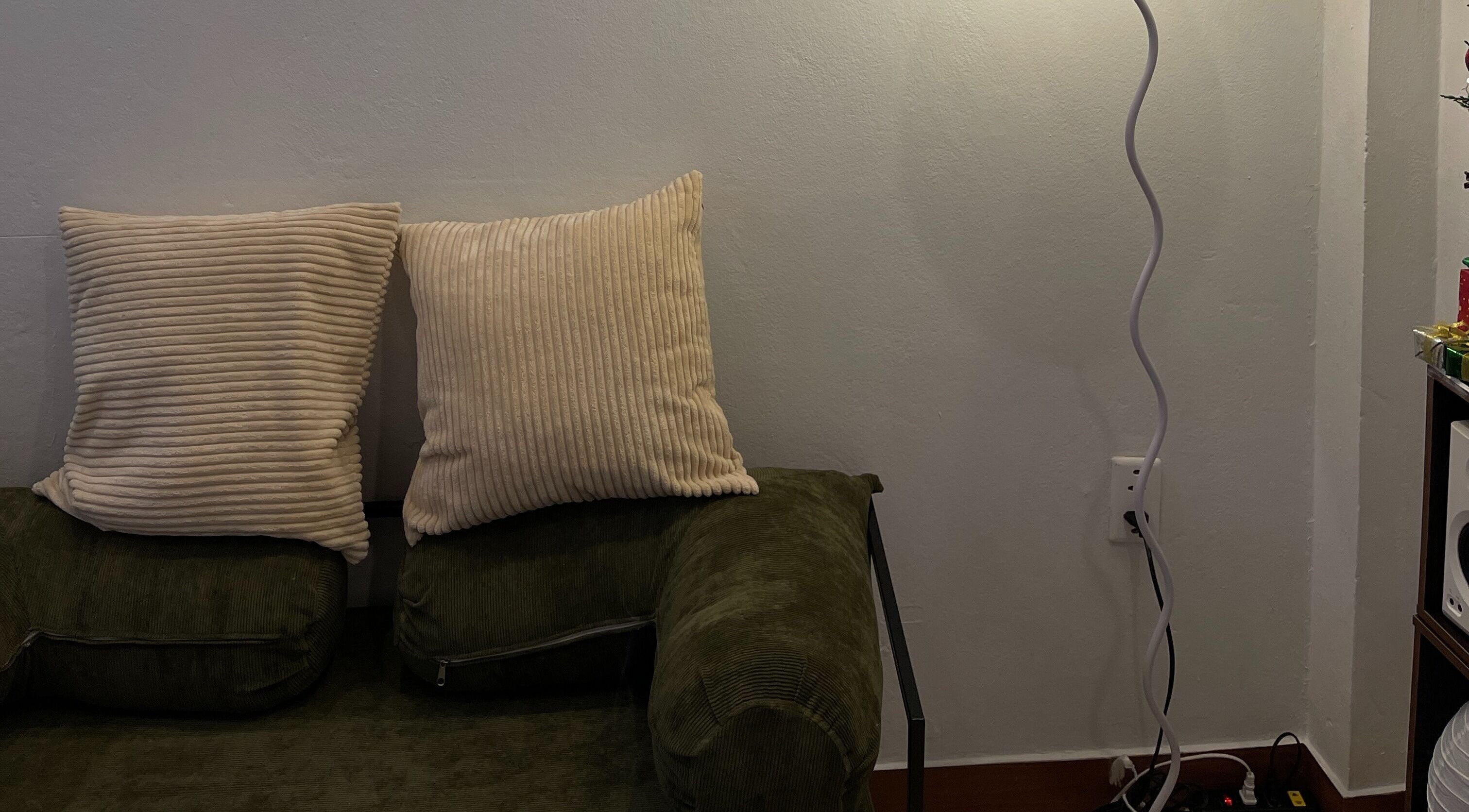 Comfortable seating area at BrowGal in Hà Nội, Hà Nội, VN, featuring a cozy green sofa with pillows and soft lighting.