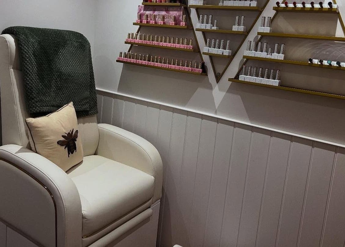 Cozy manicure chair in Blooms Beauty Room, Burgess Hill, England, GB with stylish shelves of nail products.