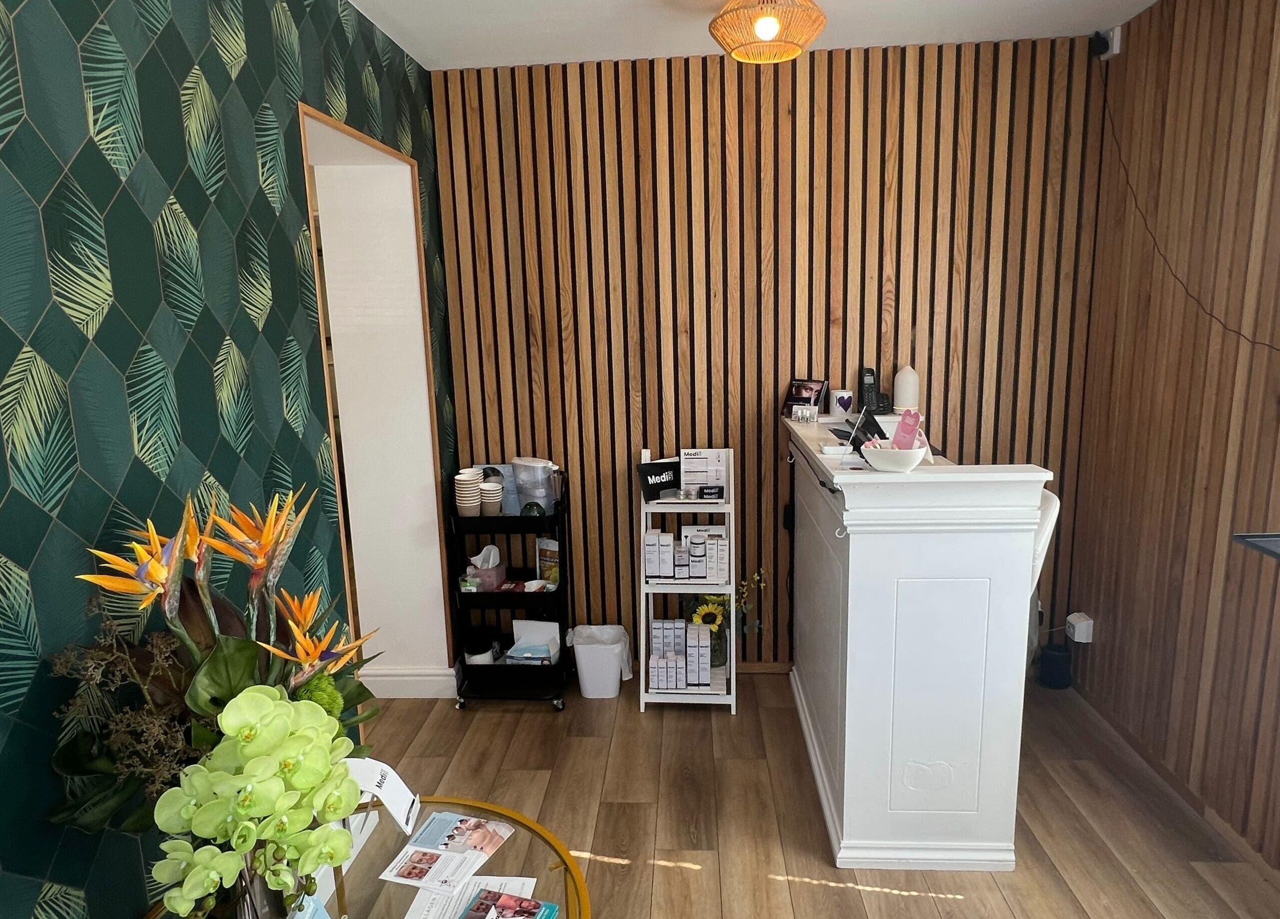 Reception area of Blooms Beauty Room in Burgess Hill, England with floral decor and wooden accents.