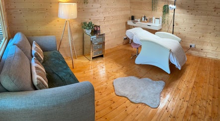 Cozy interior of Yasmin Jennifer Beauty in Loughborough, England, GB with a massage table and sofa.
