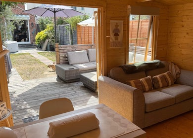 Cozy seating area at Lumora Belle Beauty, Loughborough, England with garden view and natural wood accents.